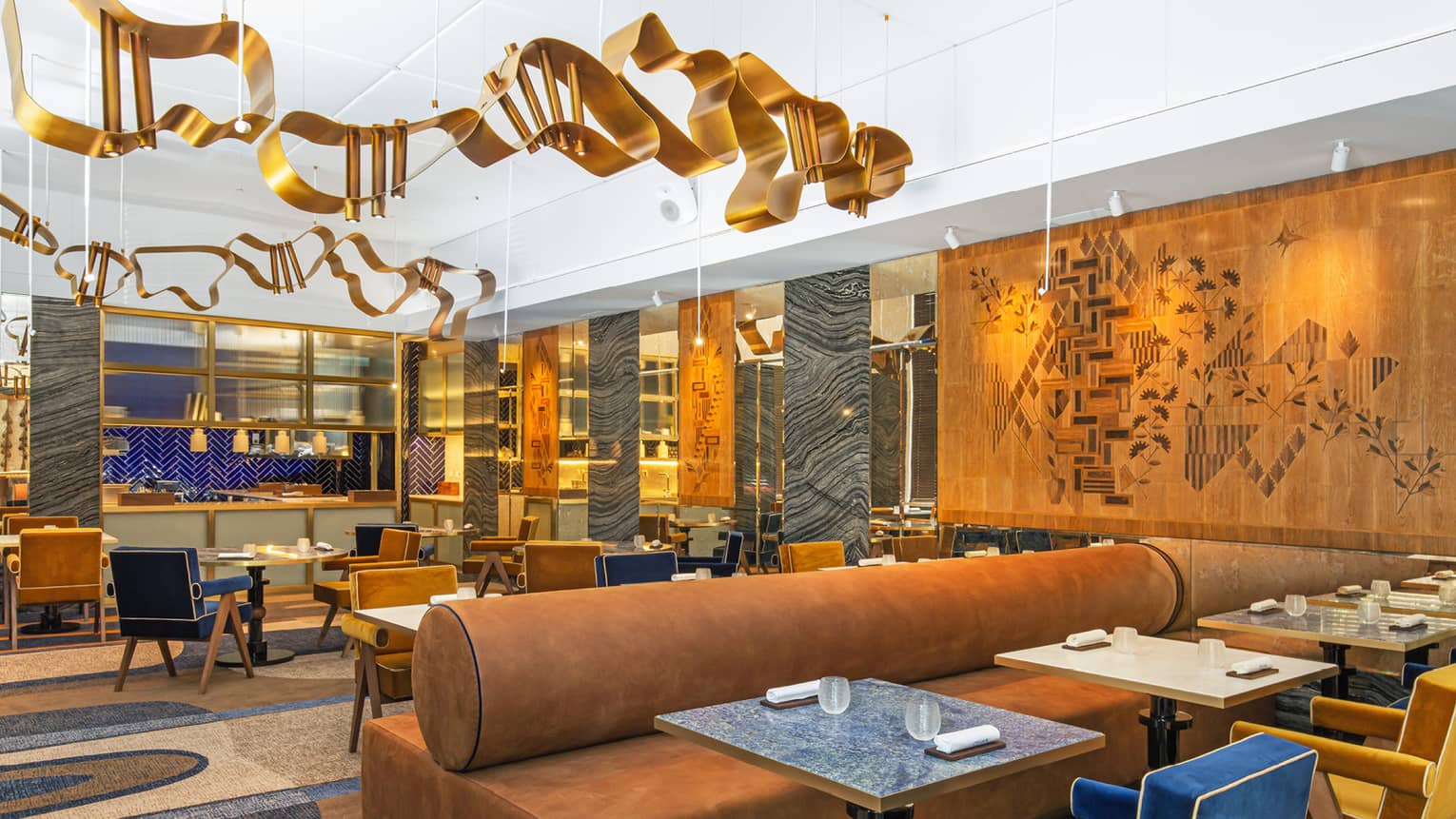 Modern dining area with gold, blue and deep camel accents and art flanking walls and ceiling