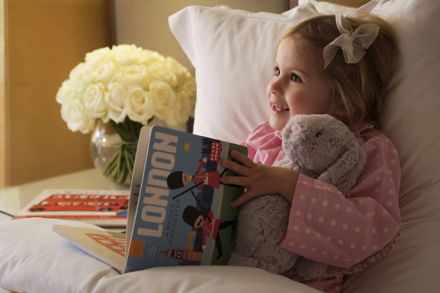 Little girl reads London picture book in bed