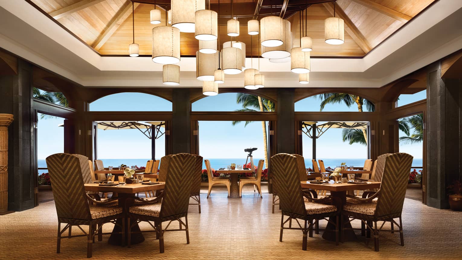 Views Restaurant dining room, tables and chairs under vaulted ceilings with modern lanterns