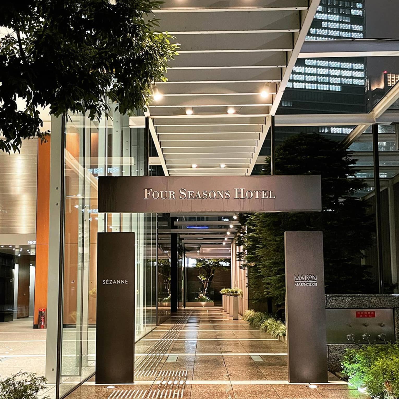 Entrance of Four Seasons with illuminated signage and modern architecture at night