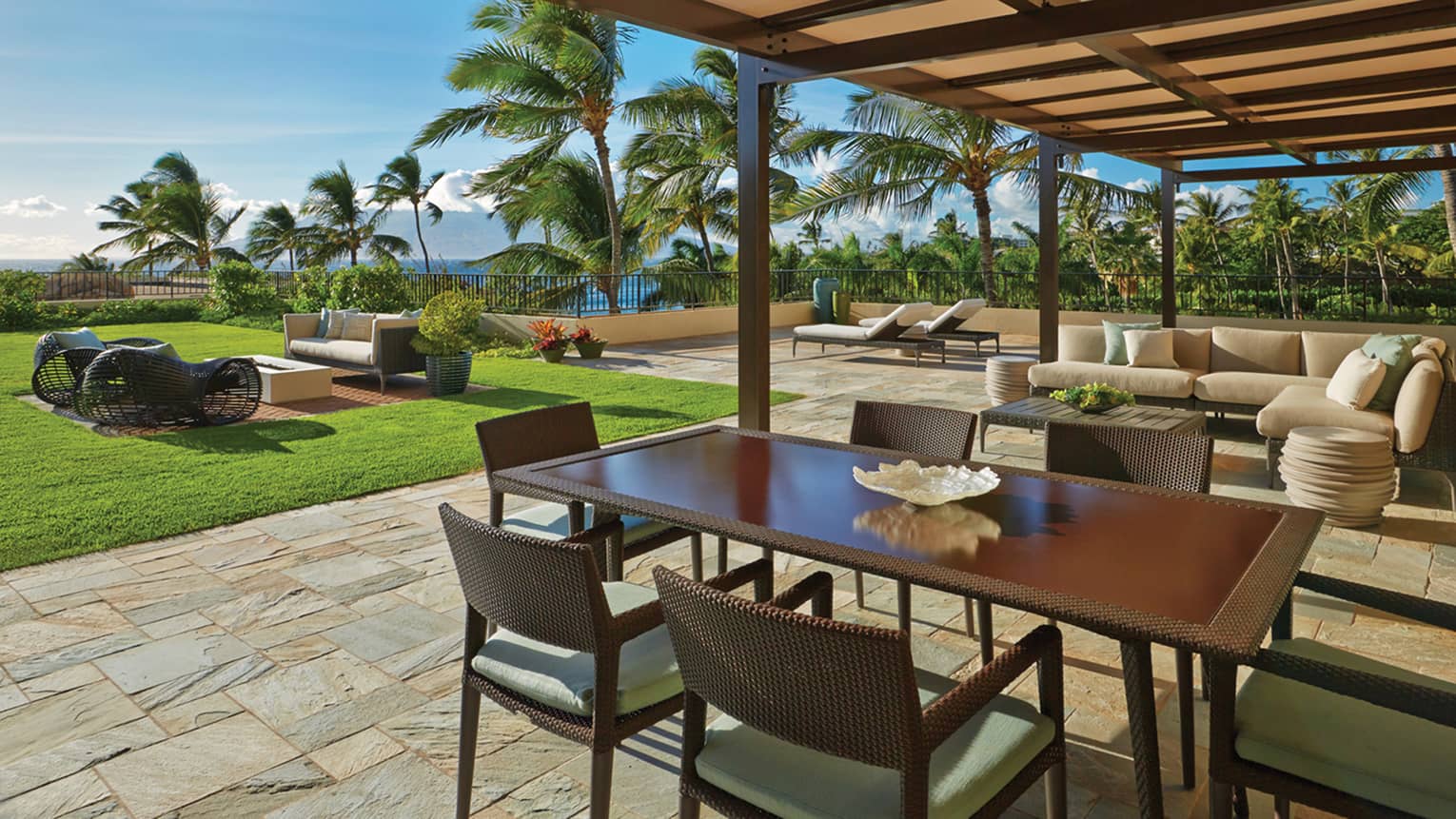 Lokelani Presidential Three-Bedroom Suite sunny outdoor patio with sofas and wicker dining table