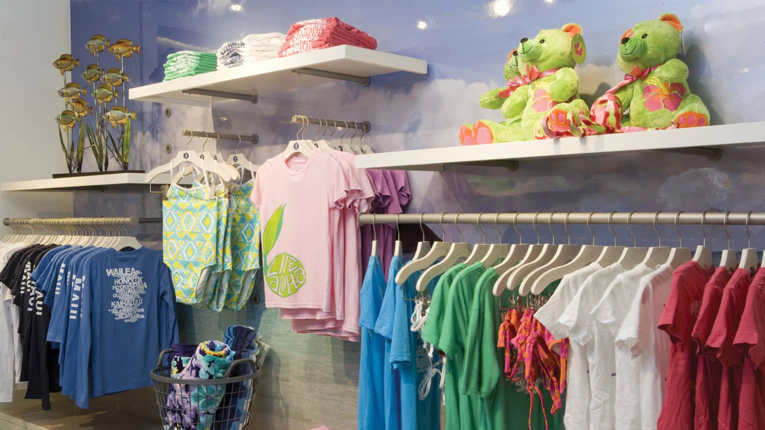 Wall of clothing boutique with racks of children's clothes on hangers, toys and towels