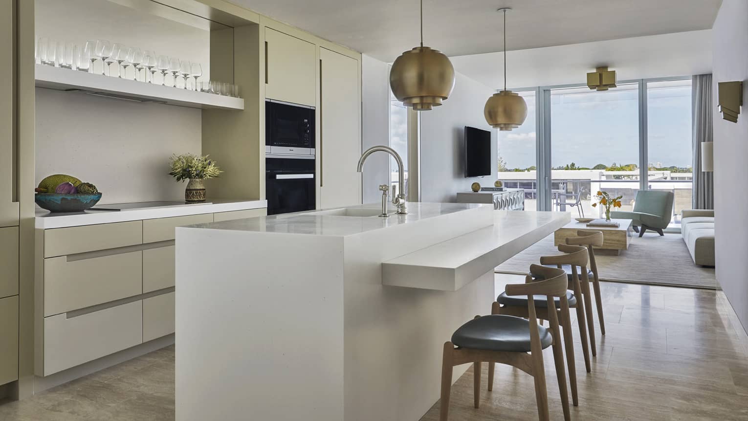 Long white island counter with stools in bright, modern kitchen