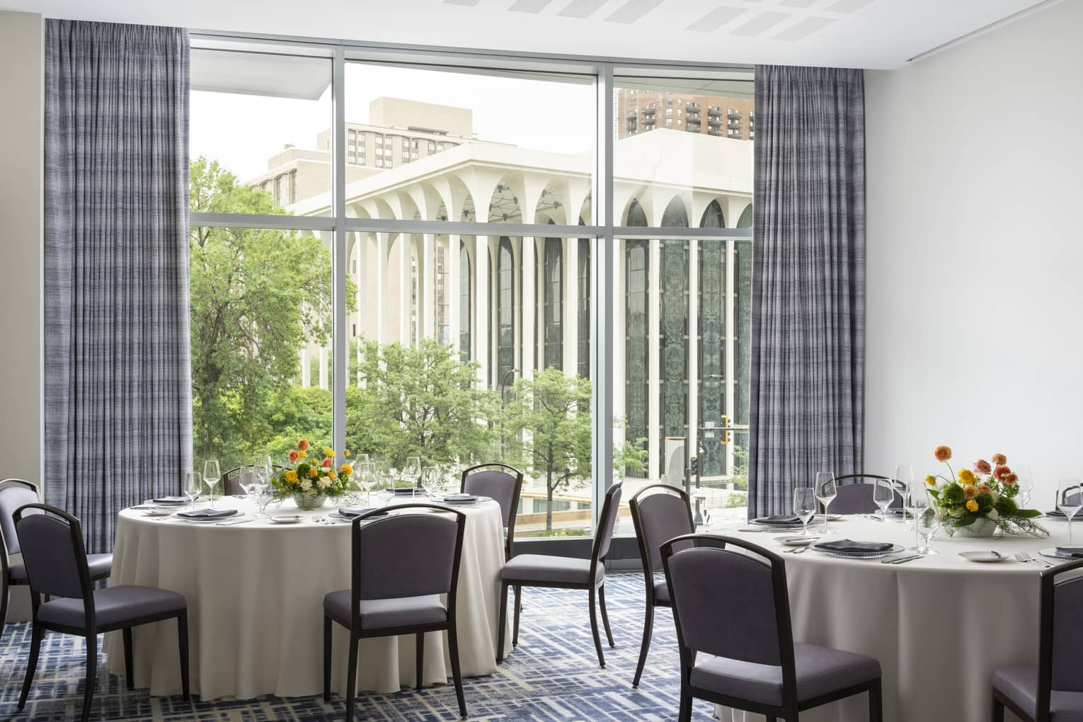 A meeting room with round tables and a large window.