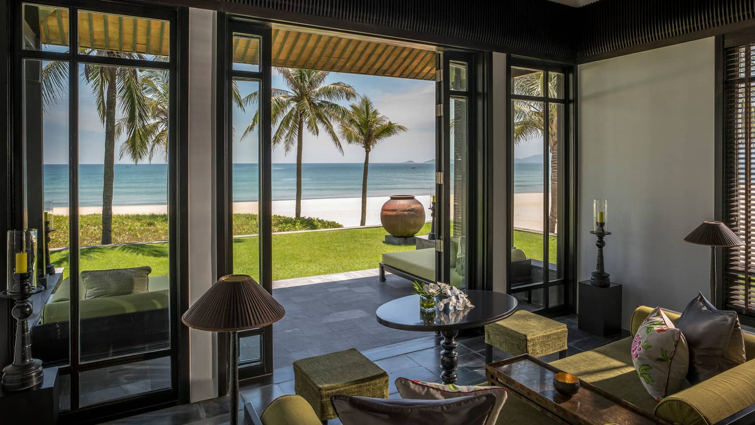 Beachfront Villa living room with open walls to lawn, palm trees, beach, ocean