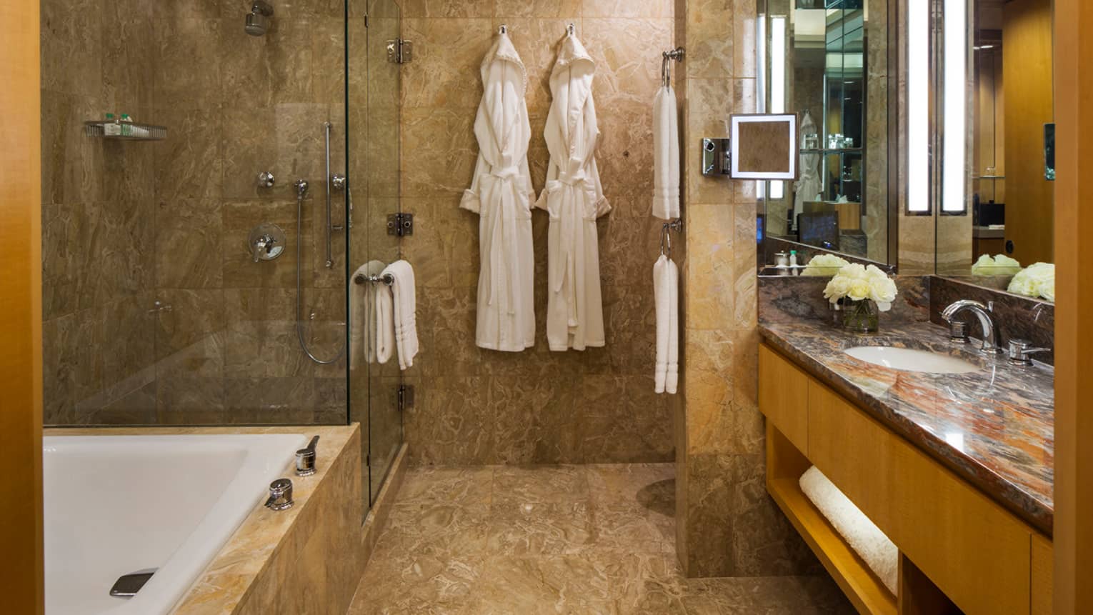 Gotham Suite bathroom, two white robes hanging on wall by walk-in glass shower, tub