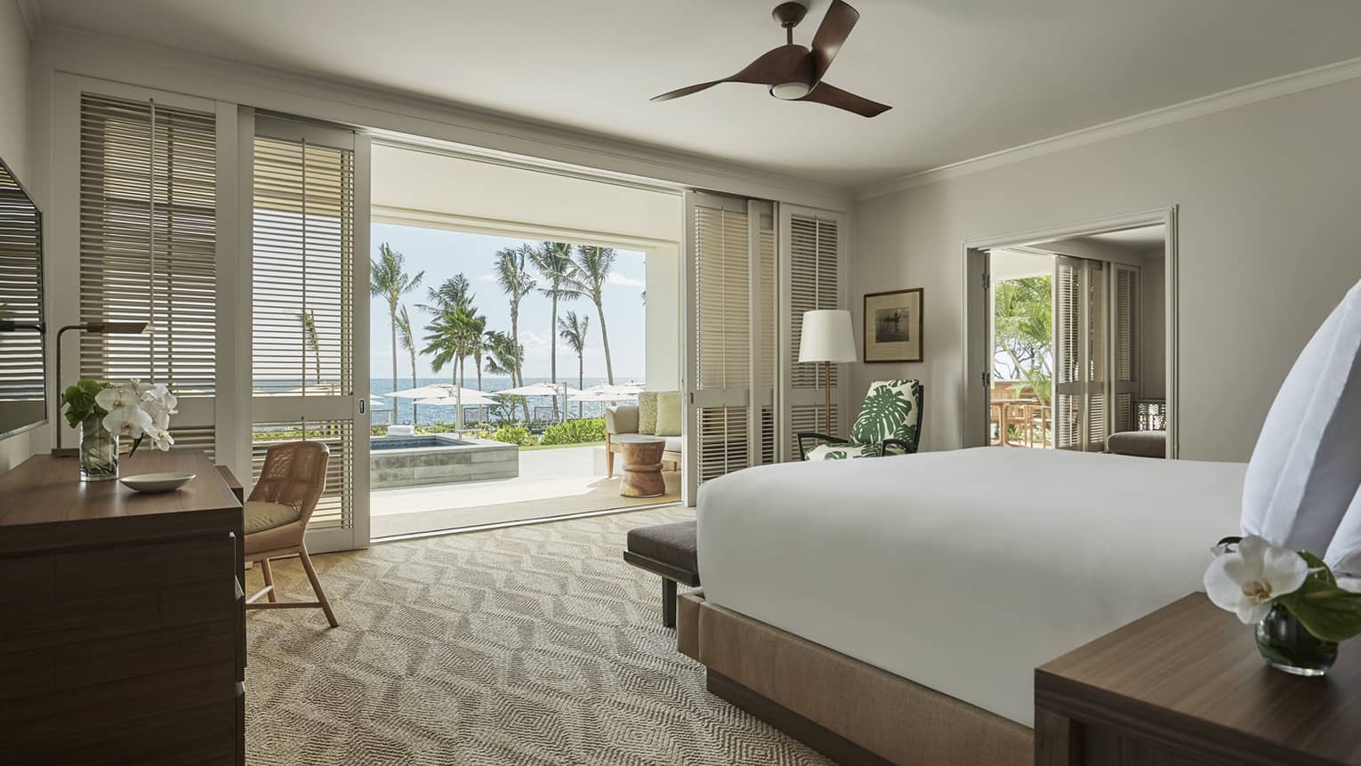 Pacific Suite bedroom, desk, end of bed facing sliding white shutters to balcony