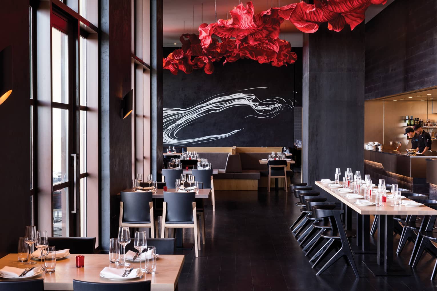A red sculpture on the ceiling and red and white accents illuminate the Capa dining room