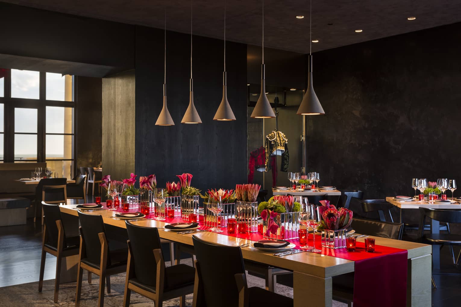 Long table with red runner under row of lamps in San Sebastian private dining room