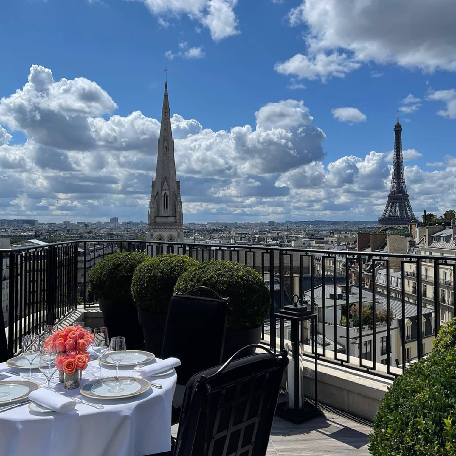 Hotel balcony with fine dining table and view of Eiffel Tower