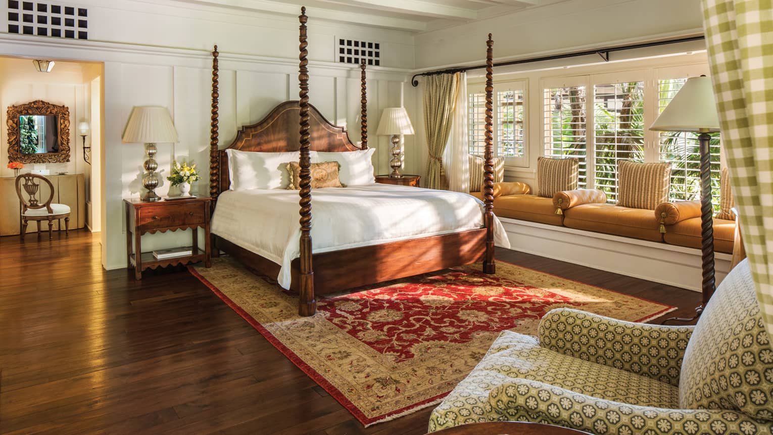 Poster bed in sunny Ty Warner bungalow bedroom, built-in cushioned bench under long window