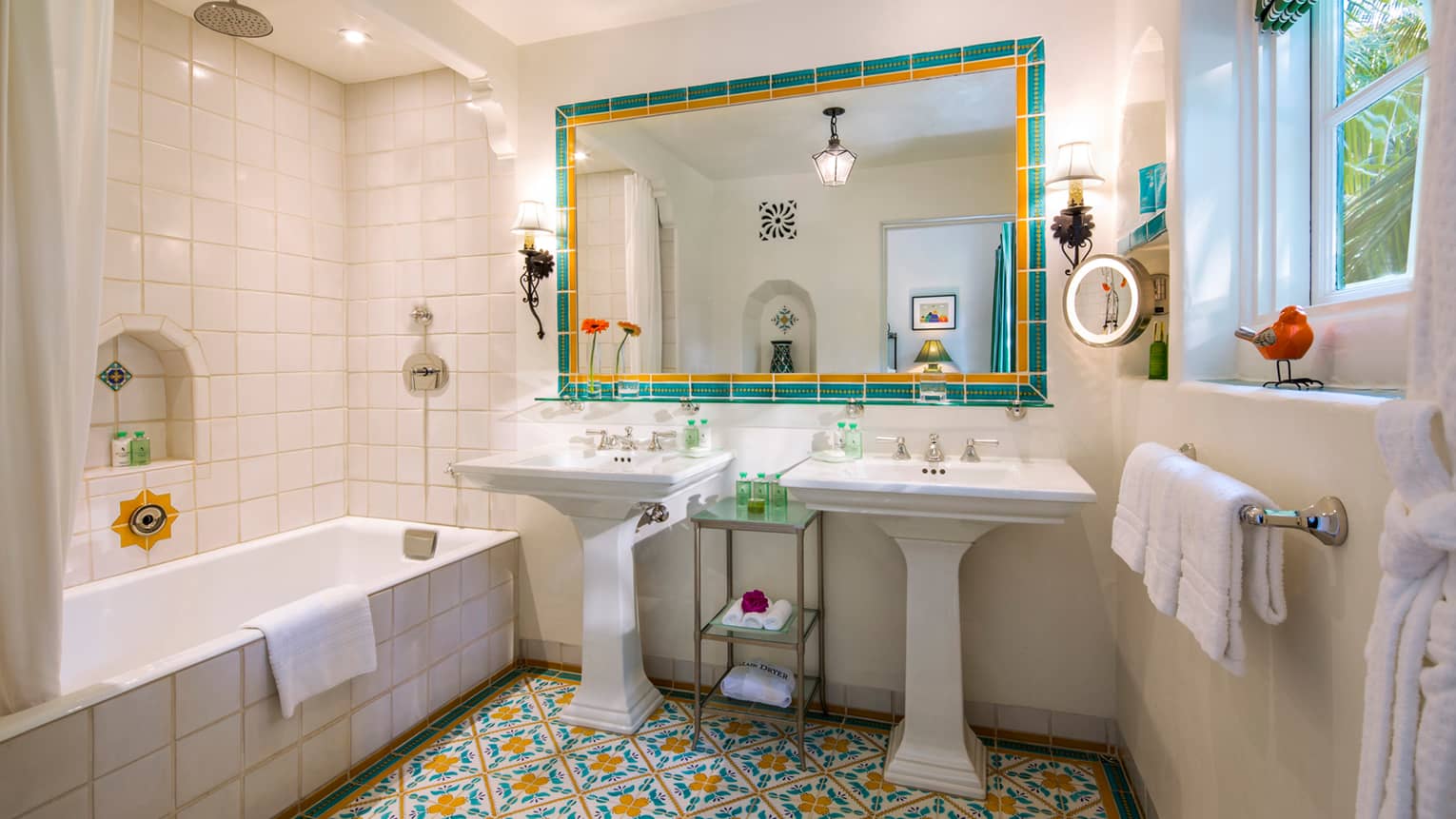 Mariposa Suite bathroom double free-standing sinks, large mirror, TV, colourful Spanish tiles