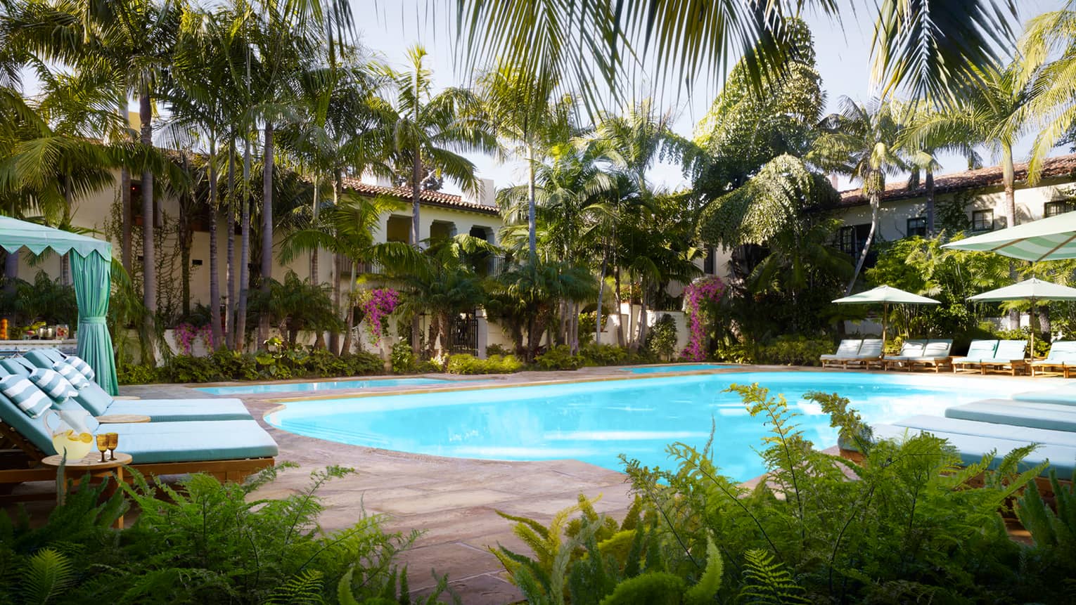 Tropical trees, plants, lounge chairs and cabanas around Jungle Pool