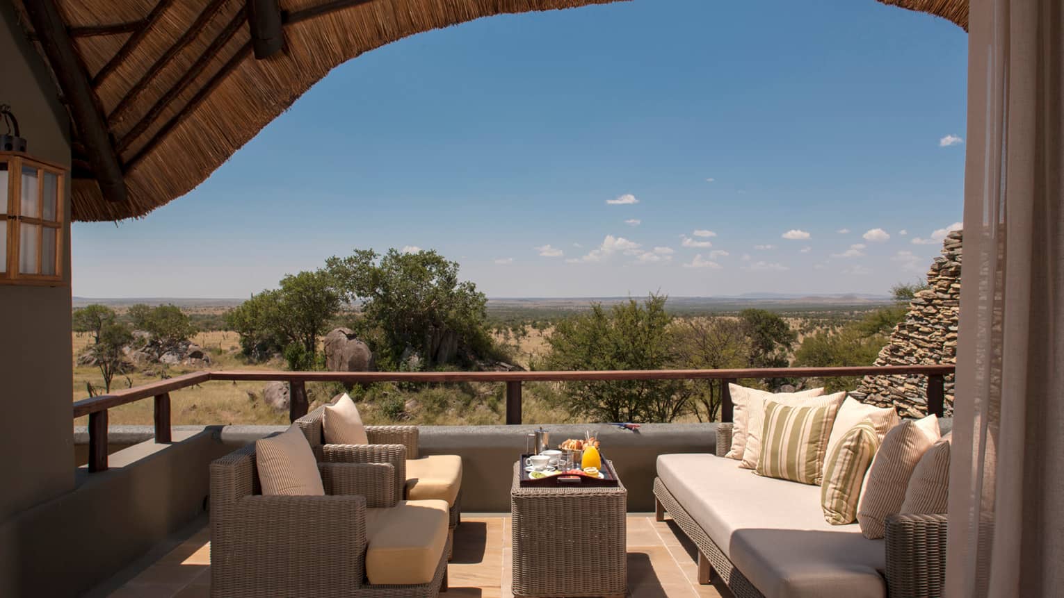 Horizon Room Waterhole covered patio with wicker chairs, sofa, breakfast tray