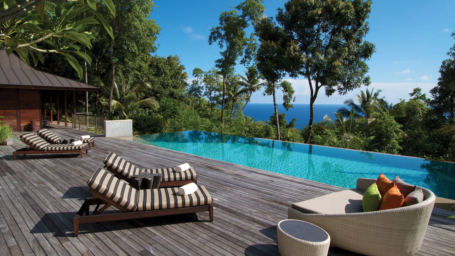 Pool chairs side-by-side beside swimming pool, trees