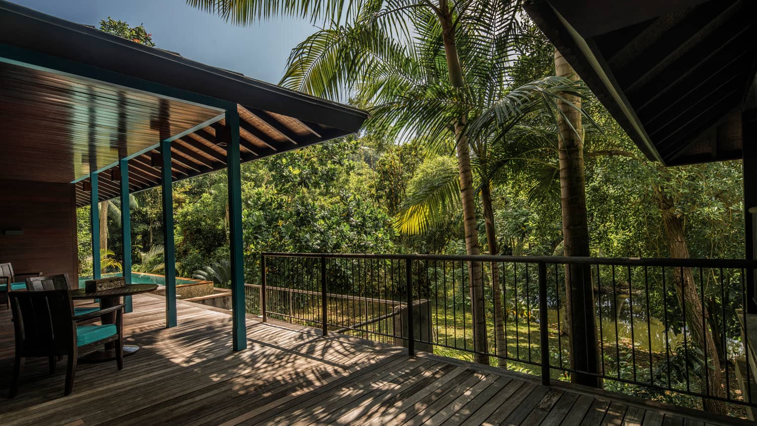 Palm trees cast shadows over Garden Villa wood deck, roof