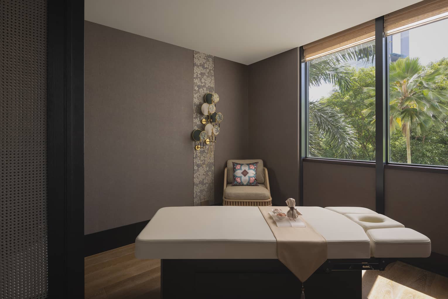 massage table with a view of the jungle outside the window