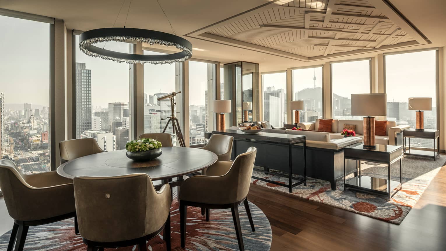 Sejong Two-Bedroom Suite round dining table under modern chandelier, seating area, corner windows