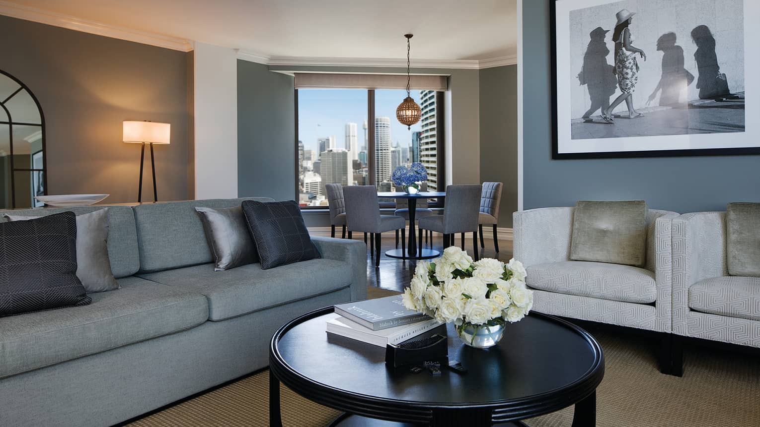 Royal Suite sofa with silver pillows, round table, black-and-white framed print, dining alcove