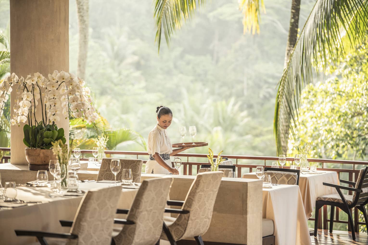 Hotel staff sets restaurant table in Ayung Terrace