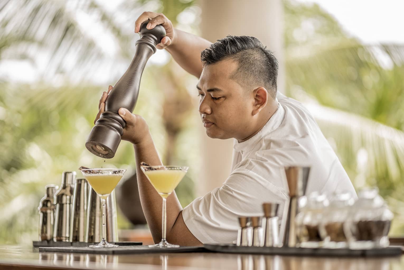 A bartender garnishing a drink with spices in Bali