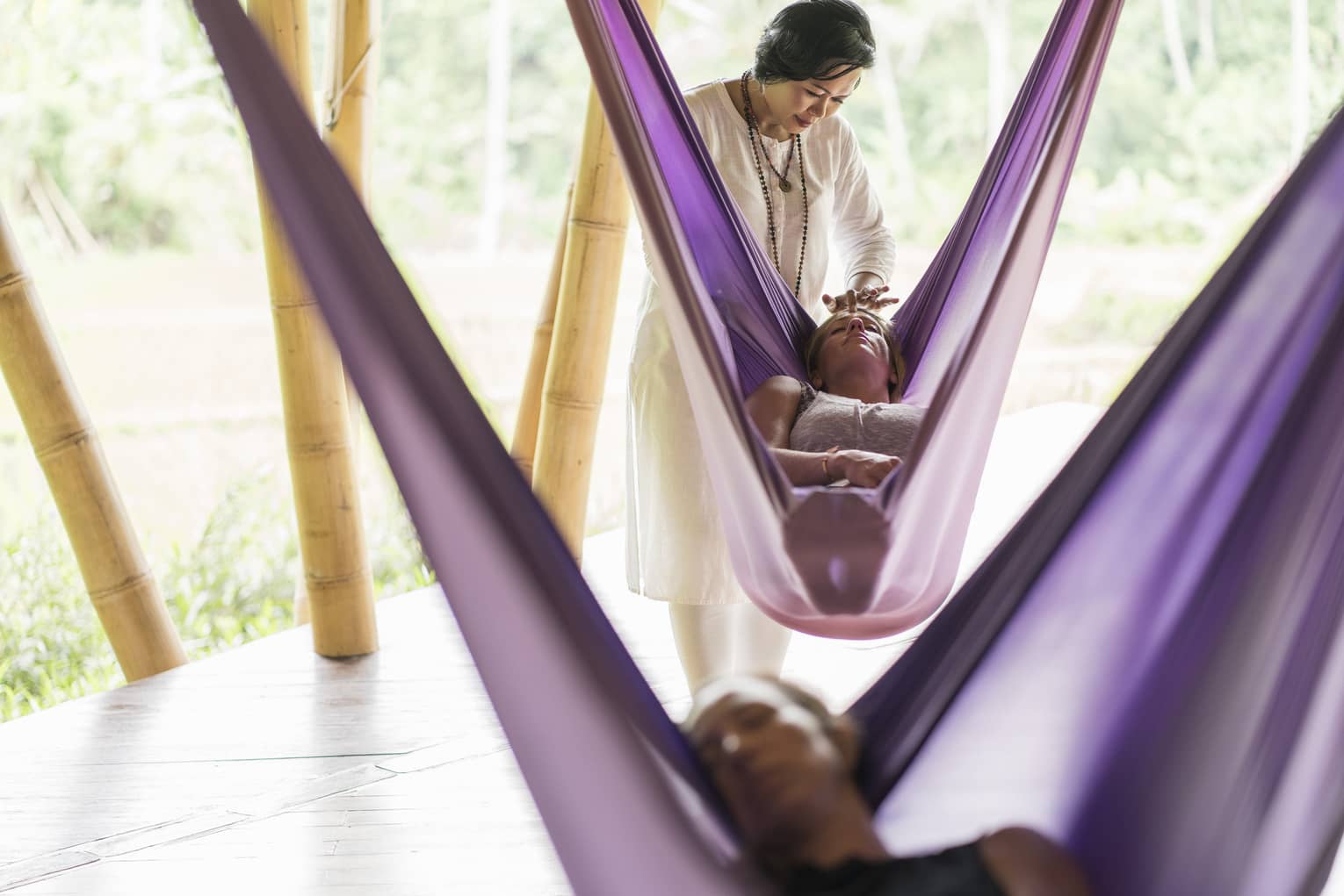 A Four Seasons yoga instructor massages the forehead of a guest during a sacred nap 