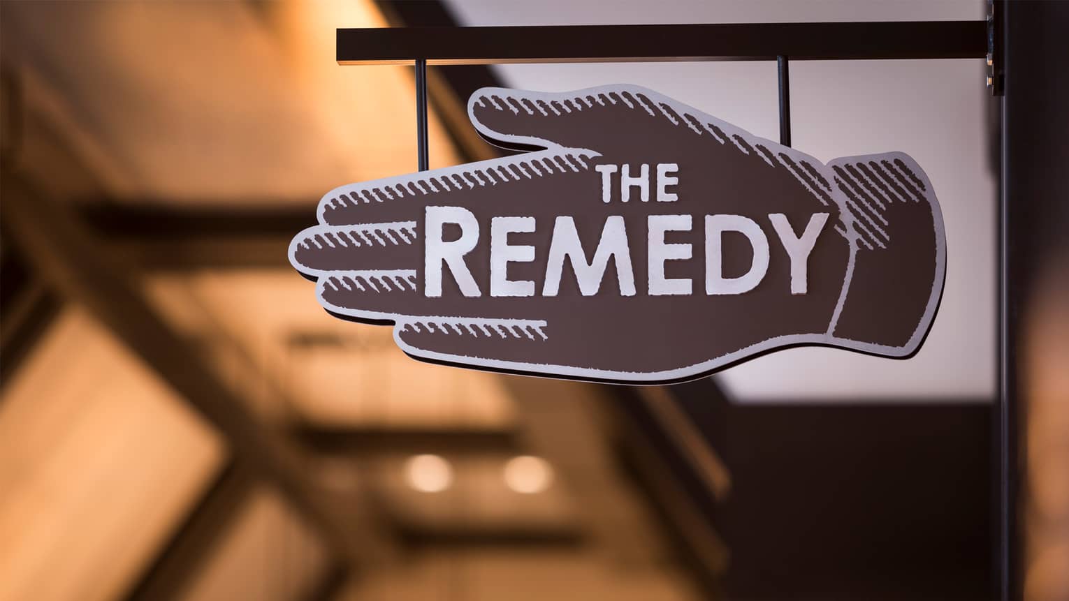Close-up of The Remedy Bar brown-and-white hand-shaped sign