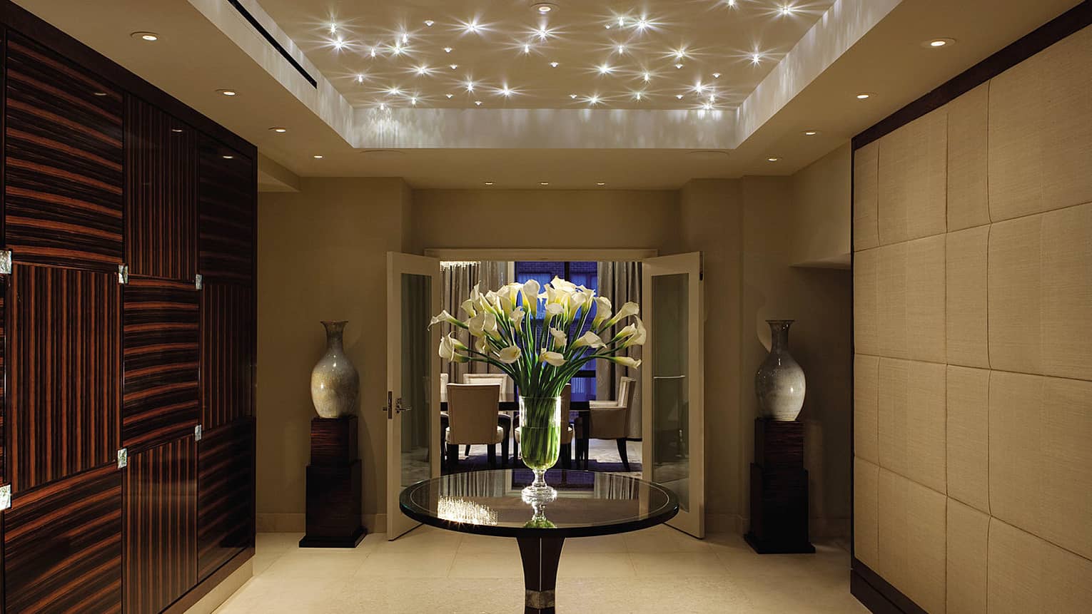 Royal Suite art deco-style private hallway under sparkling lights, door to private dining room at night