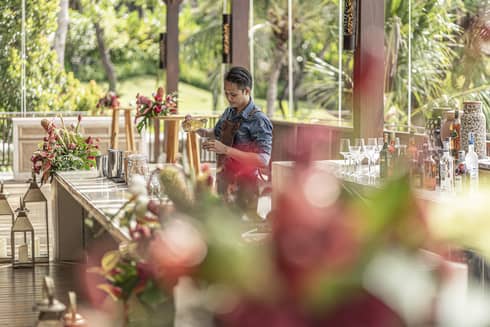 Bartender mixes drink at outdoor bar