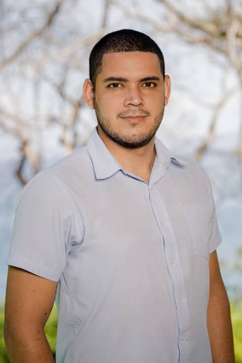 Melsar Guzman stands outside wearing a light-blue, short-sleeve shirt