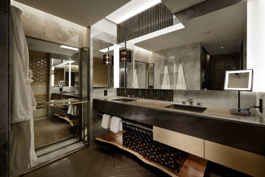 Luxurious bathroom with a double-sink vanity, marble accents, ambient lighting and mirrors